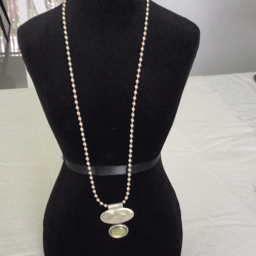 Woman’s Metal Necklace with a light green stone. Can wear with anything.